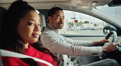 Dope Candi and Jay Ellis smiling inside a Nissan car