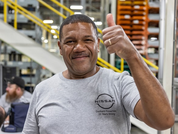 Smiling Nissan employee giving a thumb sign