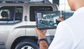 Hombre tomando una foto de la camioneta Nissan en una tableta