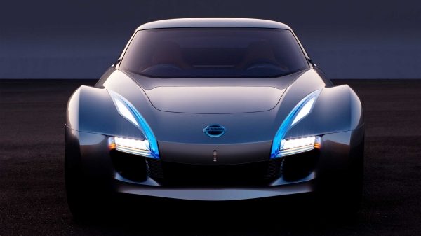 Front view of the ESFLOW electric sports car concept shown in silver with its long hood, sharply angled wraparound windshield, and discreet rearview cameras in place of outside mirrors.