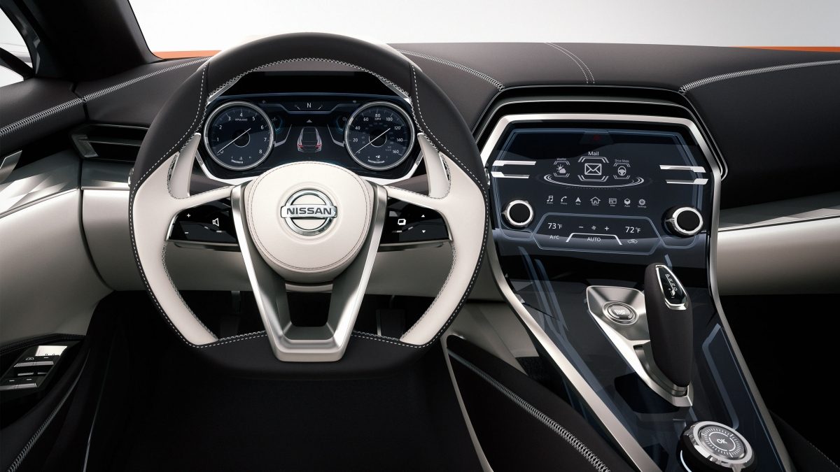 Close up view of the Nissan Sport Sedan sporty steering wheel and dashboard with silver trim.