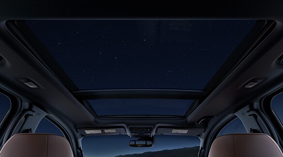 Vista de noche estrellada desde el asiento trasero de la Nissan TITAN 2023 con techo corredizo panorámico doble.