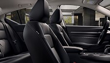 Vista del interior de los asientos delanteros y traseros del Nissan Altima 2022 desde la puerta del pasajero.