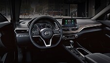 Vista del Nissan Altima 2022 desde el asiento del conductor con volante, controles, consola central y pantalla táctil.