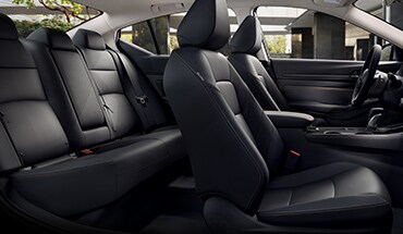 Vista interior de los asientos delanteros y la puerta del pasajero abierta del Nissan Altima 2023.