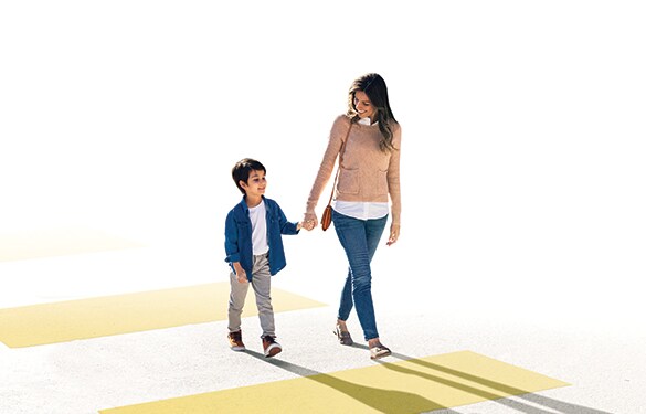 Nissan Ariya 2023 con madre e hijo tomados de la mano en un paso de peatones