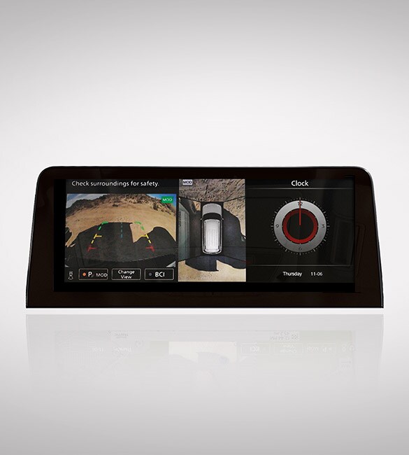 Pantalla táctil sobre fondo blanco que muestra las vistas de la cámara del monitor de visión inteligente y el reloj del Nissan Armada 2022.