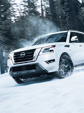 Nissan Armada 2023 conduciendo fuera de la carretera en un bosque nevado