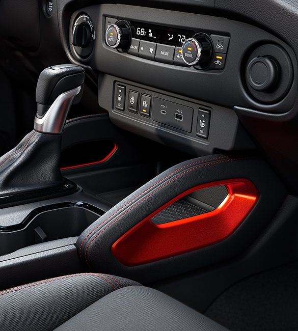 Consola central de la Nissan Frontier 2022 con detalles en color Lava Red.