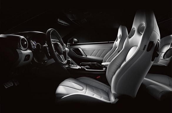 Vista interior del Nissan GT-R 2003 con asientos deportivos de piel.