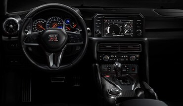 Vista interior del panel de instrumentos tipo cabina de autos de carrera del Nissan GT-R 2024.