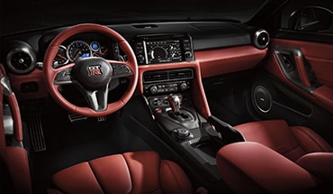 Vista del interior del Nissan GT-R 2024 muestra el volante forrado en piel y los asientos de piel.