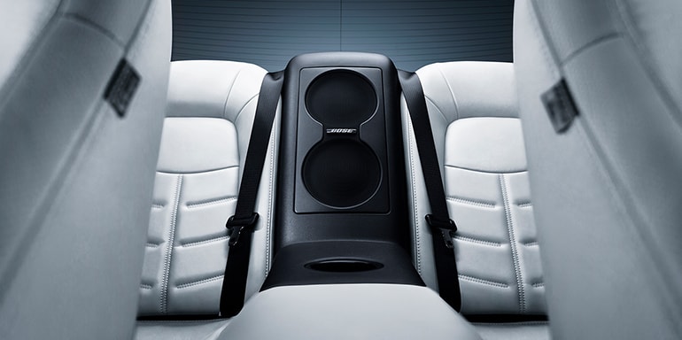 Vista interior de los asientos traseros mostrando las bocinas del sistema de audio premium Bose del Nissan GT-R 2024.