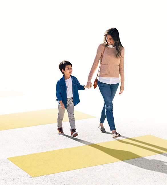 El Nissan LEAF 2022 con vista de una madre cruzando el paso de peatones con su niño