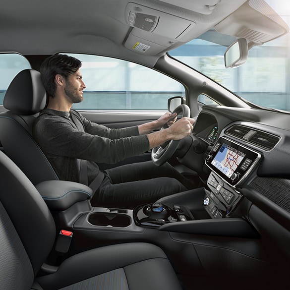 El Nissan LEAF 2024 mostrando a una persona conduciendo sentada en asiento de tela ecológica