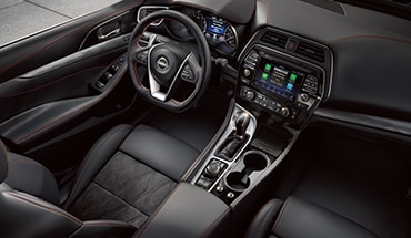 Cabina del Nissan Maxima 2023 con los controles del conductor y la tecnología de conexión en la pantalla táctil.