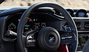 Vista de la cabina del Nissan Z 2023 con volante, tablero, panel de instrumentos y pantalla táctil.