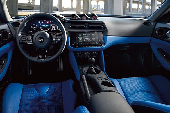Cabina orientada al conductor del Nissan Z 2023 en Blue que muestra la palanca de cambios, los instrumentos y las pantallas digitales.