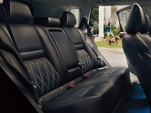 Vista interior del Nissan Rogue 2023 con asientos de piel acolchada en tono negro.