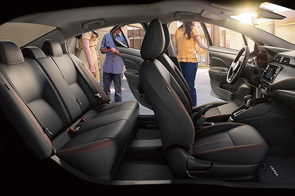 Se muestra el espacioso interior del Nissan Versa 2022 mientras se suben personas en los asientos traseros y delanteros.