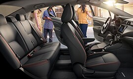 Se muestra el espacioso interior del Nissan Versa 2022 mientras se suben personas en los asientos traseros y delanteros.