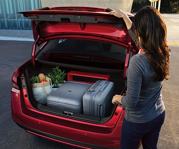 Vista trasera del Nissan Versa 2024 con un gran maletero de fácil acceso con equipaje y comestibles en su interior