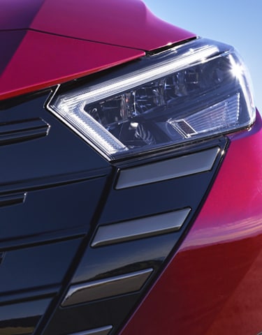 Detalle frontal del Nissan Versa 2024 muestra las icónicas luces LED de día